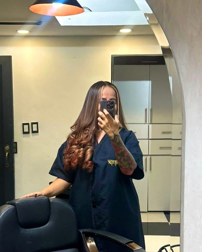 Después: la misma clienta con el cabello castaño, mechas claras y ondas en las puntas.